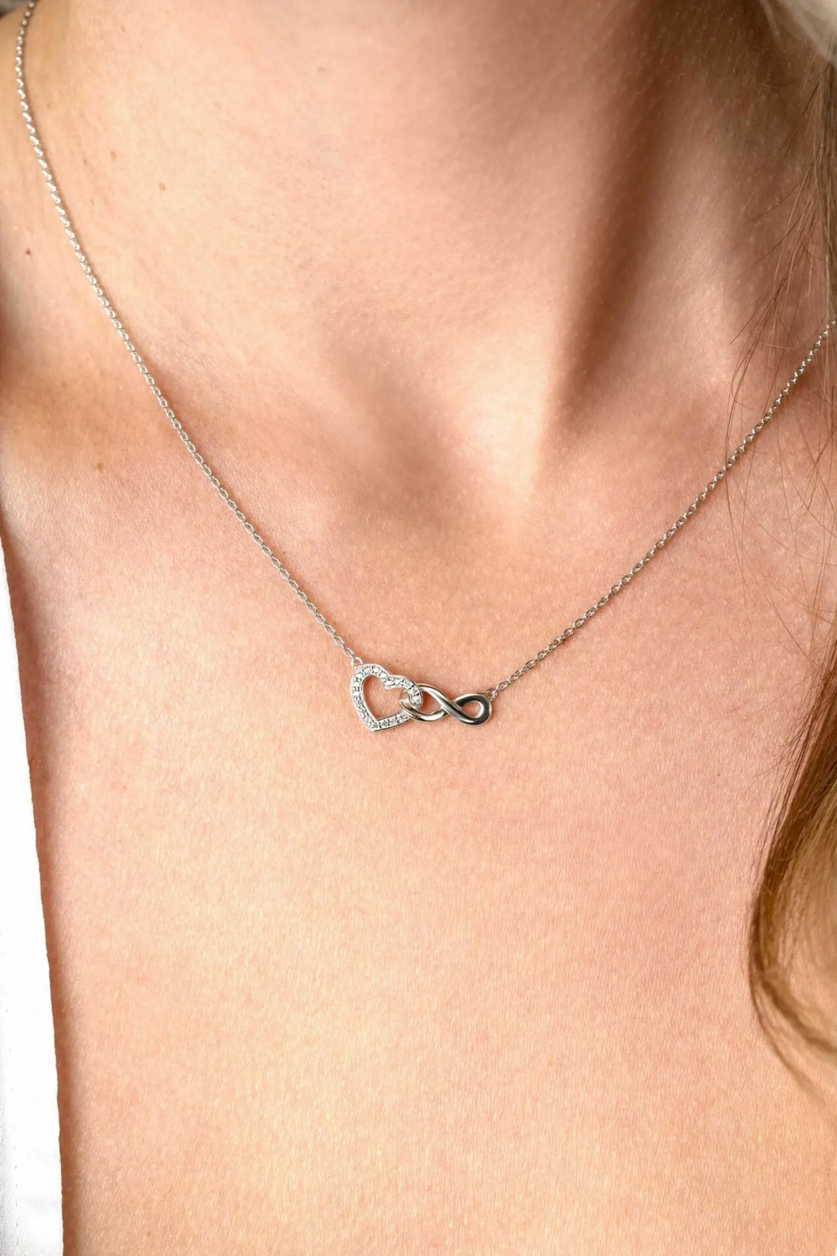 ZINZI zilveren ketting met Infinity teken verbonden met een open hart, bezet met witte zirconia's 42-45cm ZIC2596