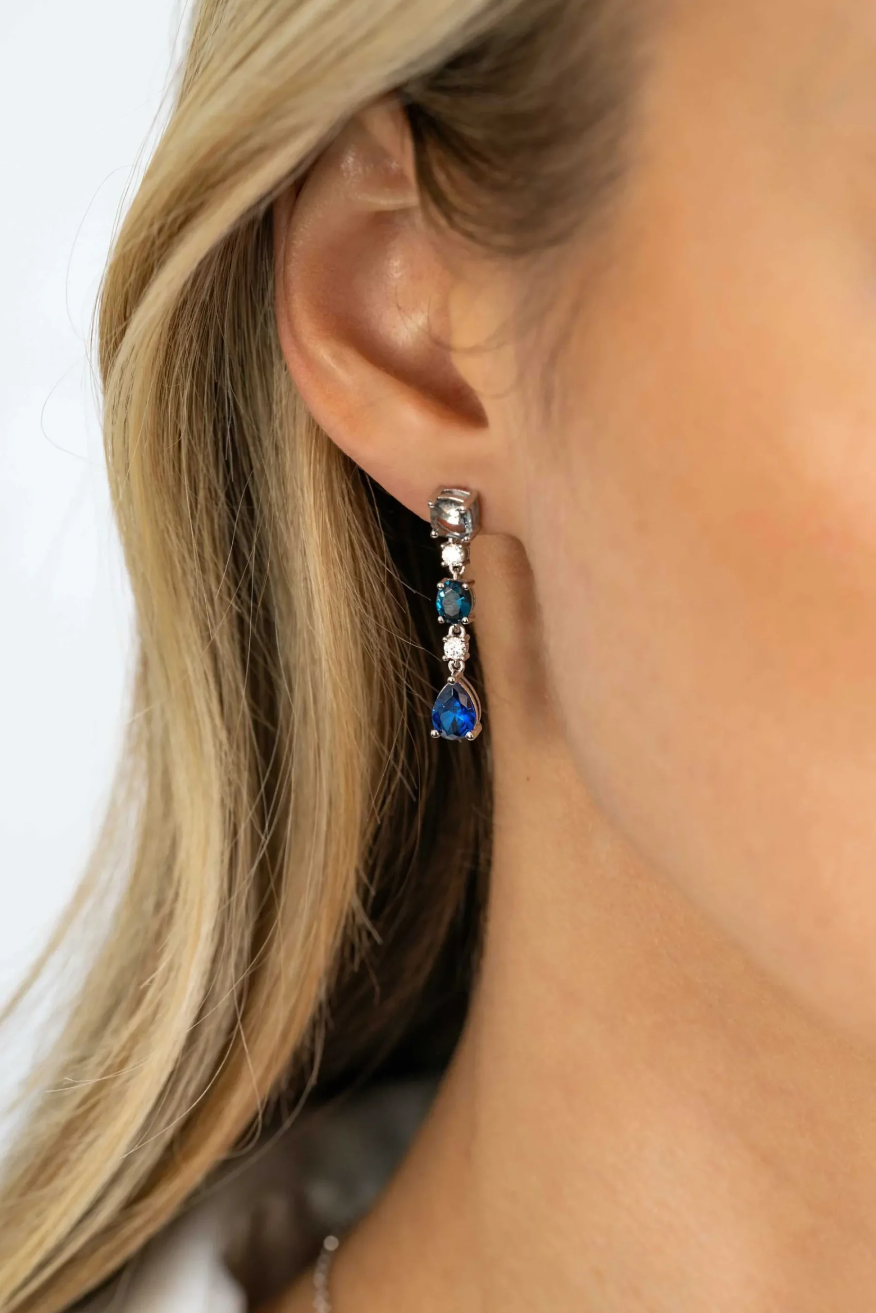 ZINZI zilveren lange oorsieraden 29mm met een prachtige combinatie van blauwe kleurstenen. In vierkant, ovaal en peervorm, afgewisseld met kleine witte zirconia's. ZIO2397