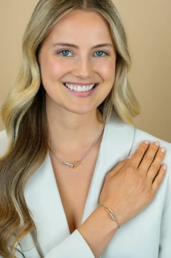 ZINZI zilveren schakelarmband met twee verbonden ovale schakels: ene gold plated, ander bezet met witte zirkonia's ZIA2758